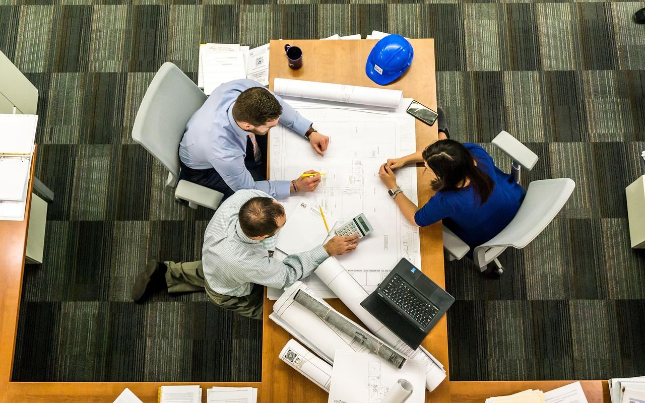 Équipe d'une PME manufacturière québécoise qui révise ses plans autour d'une table de travail
